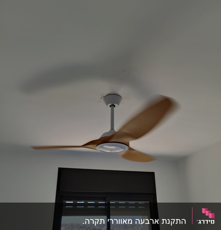 מאוורר תקרה מסתובב בחדר עם חלון